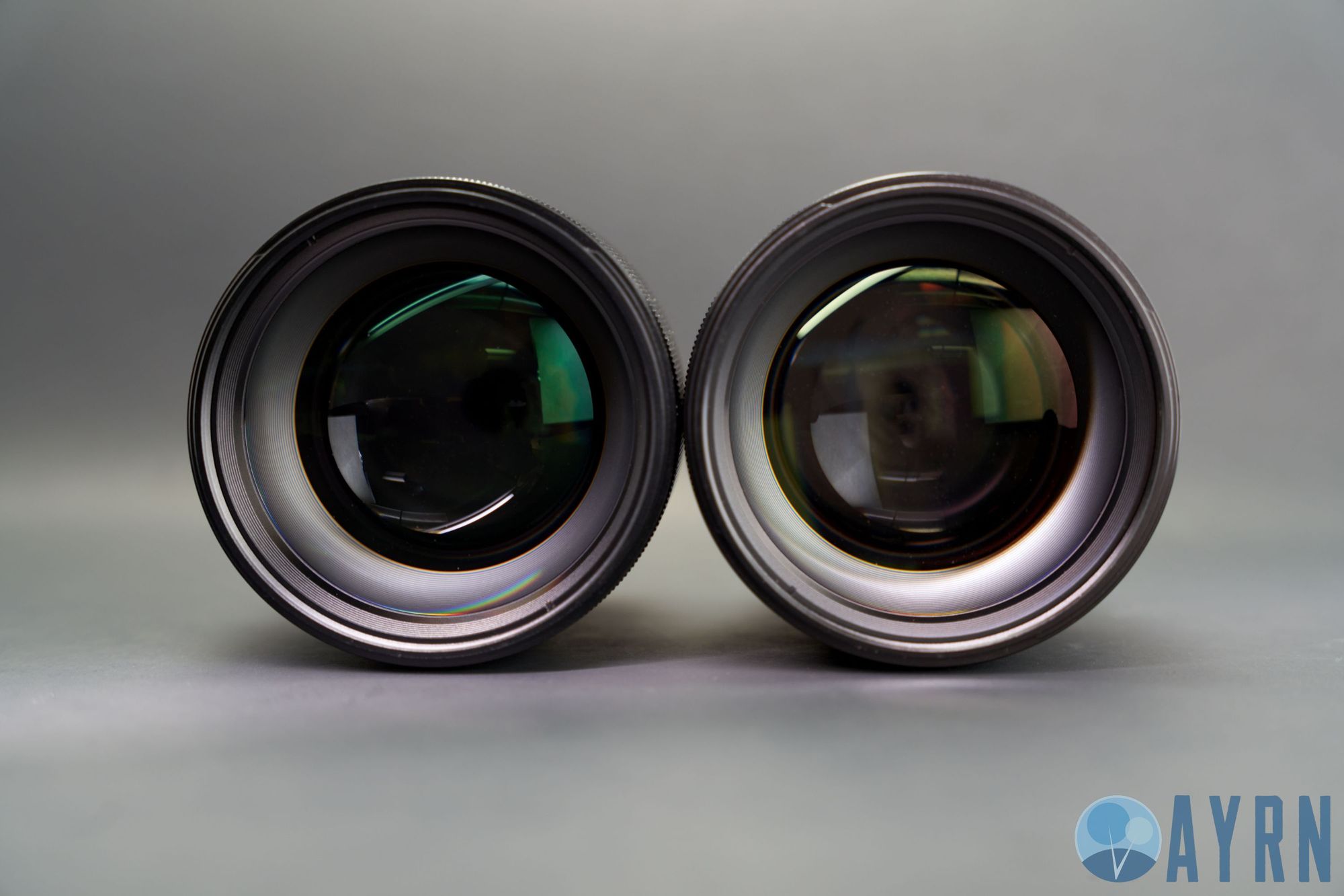 Side by side image of the Viltrox 85mm f1.8 STM (left) and Tokina ATX-M 85mm f1.8 (view of front elements)