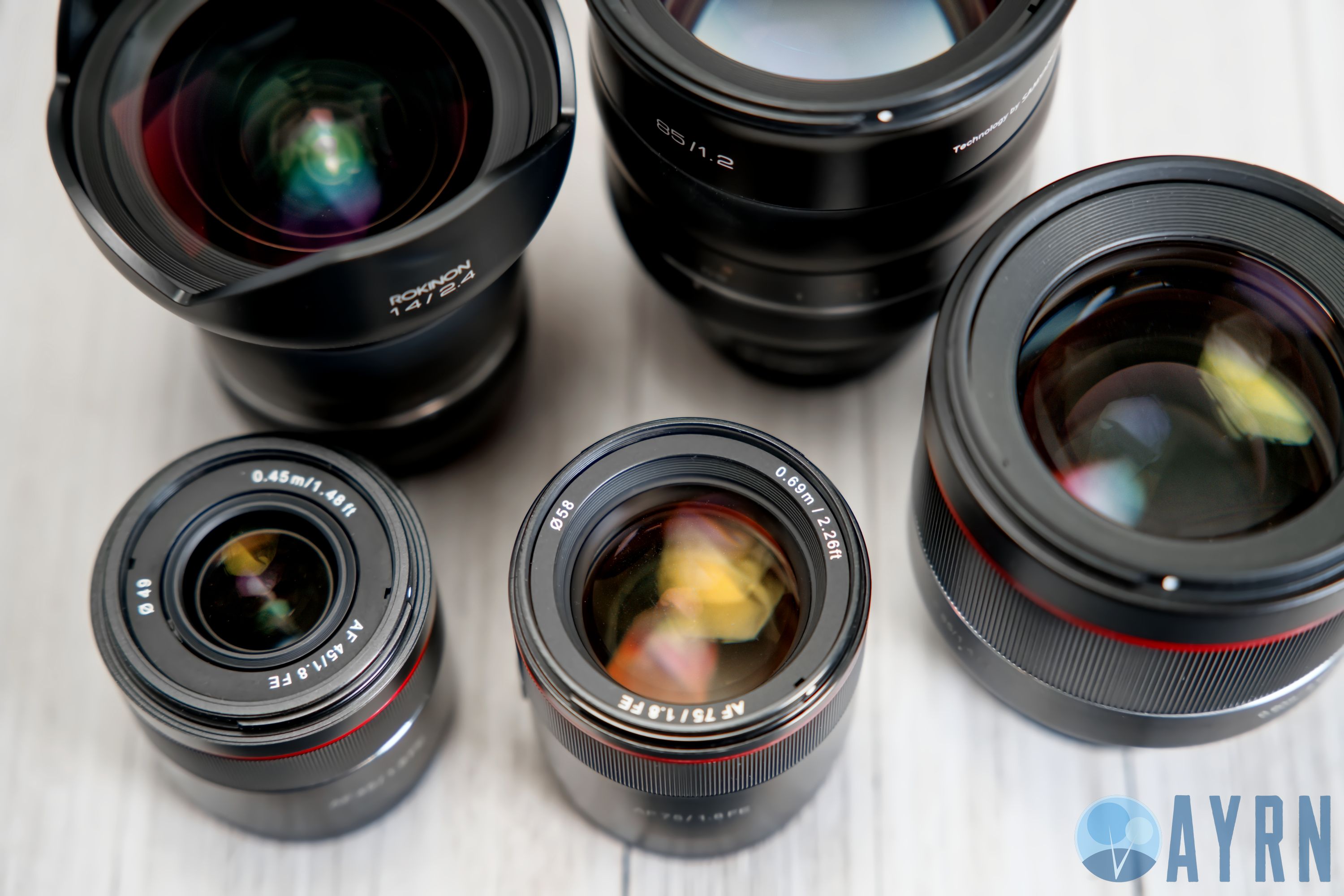 FOR SIZE COMPARISON, TOP LEFT TO BOTTOM RIGHT: ROKINON 14MM F/2.2 XP, ROKINON 85MM F/1.2 XP, ROKINON AF 85MM F/1.8 FE, ROKINON AF 45MM F/1.8 FE, ROKINON AF 75MM F/1.8 FE 